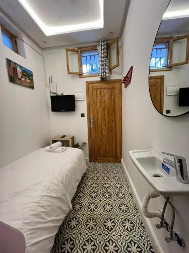 a small bedroom with a bed and a sink at Chambre au cœur de la médina avec salle de bain privé in Tangier