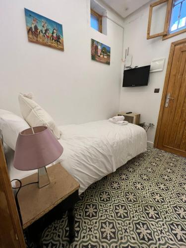 a bedroom with a bed and a lamp on a table at Chambre au cœur de la médina avec salle de bain privé in Tangier