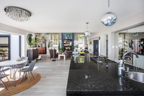 a kitchen and living room with black counter tops at Villa Blau -Stunning Beach Front House Grotto Bay Private Nature Reserve West Coast in Grotto Bay