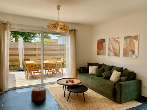 un salon avec un canapé vert et une table dans l'établissement Maison Alba, à Lit-et-Mixe