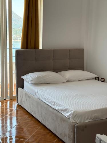 a bed in a room with a large window at Room with amazing sea view in Himare