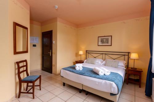 a bedroom with a bed with towels on it at Borgo San Martino - Residence Hotel & SPA in Riparbella