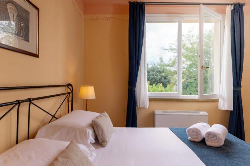 a bedroom with two beds and a window at Borgo San Martino - Residence Hotel & SPA in Riparbella