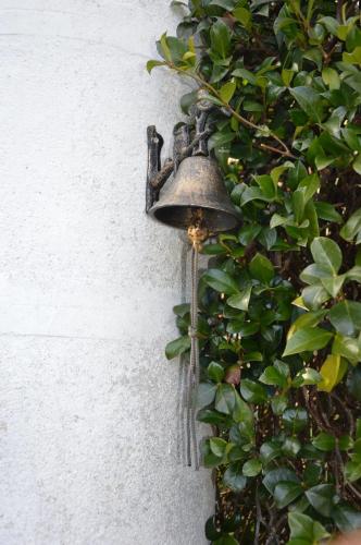 a bell hanging on the side of a wall at Cozy house near Asei with garden and terrace in Casa del Bosco