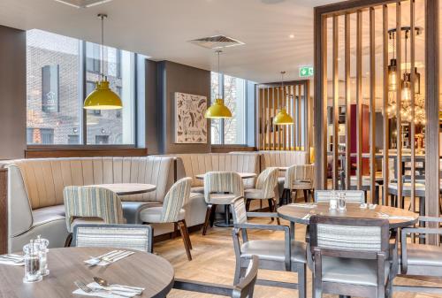 a restaurant with tables and chairs and windows at Premier Inn Dublin City The Liberties in Dublin