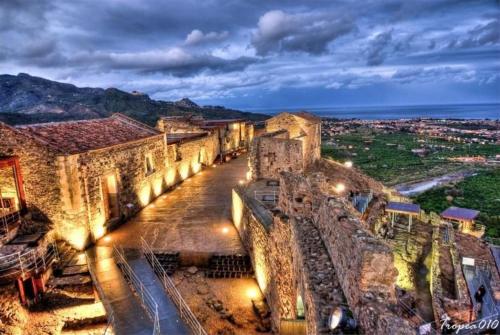 an old building with a view of a city at night at Albachiara House in Calatabiano