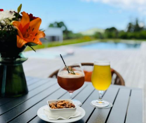 a table with two glasses and a bowl of food and a drink at Lusitano Garden Villas in Ponta Delgada