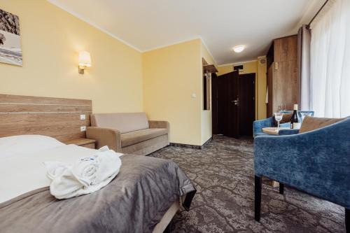 a hotel room with a bed and a chair at Hotel Na Skarpie in Szklarska Poręba