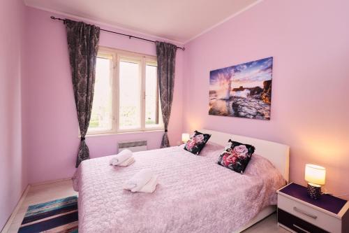 een slaapkamer met een bed met twee handdoeken erop bij Apartment Opatija 365, steps from the sea & city center, free street parking in Opatija
