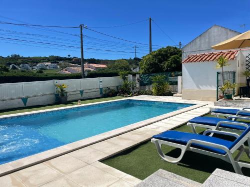 een zwembad met ligstoelen naast een huis bij Casa Vila Sao & Pompeia in Sesimbra