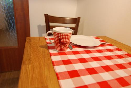 a table with a plate and a coffee cup on a checkered table cloth at Apartment Fischerbräuwiese in Bad Reichenhall