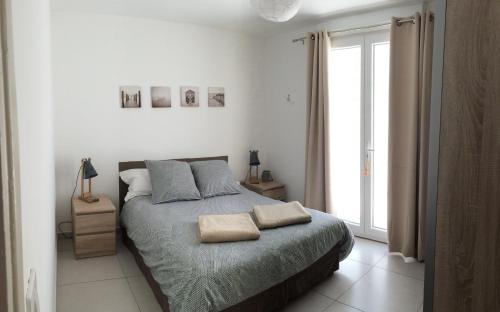 une chambre avec un lit avec deux oreillers dessus dans l'établissement La Maison Blanche, à Arles