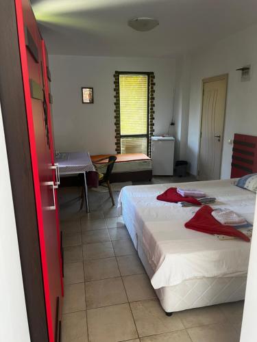 a bedroom with two beds and a table and a window at Zapovedni Rai in Primorsko