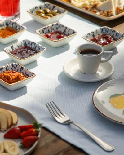 a table with plates of food and cups of coffee at Kassandra Boutique Hotel in Oludeniz