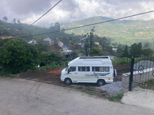 a white van parked on the side of a road at Akshay INN in Kodaikānāl