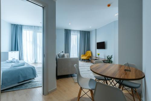 a bedroom and a living room with a bed and a table at Mziuri Gardens Apartment in Makhinjauri