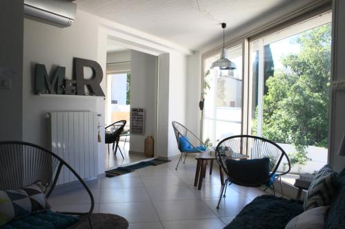 ein Wohnzimmer mit Stühlen und einem Tisch in der Unterkunft La Maison Blanche in Arles