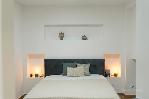 un letto bianco con testiera blu in una camera da letto di ESSE Homes Sant Elia a Santa Flavia