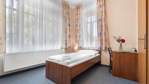 a small bedroom with a bed in front of a window at Hotel Samechov - konferenční hotel in Samechov