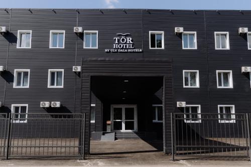 a black building with a for profit sign on it at TÖR by Uly Dala Hotels in Kostanay