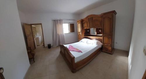 a bedroom with a large bed and a wooden cabinet at CAP NATURE Campement in Nialon