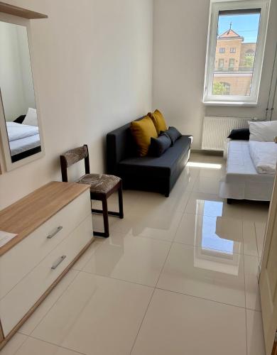 a living room with a black couch and a mirror at Peron Vendégház in Szeged