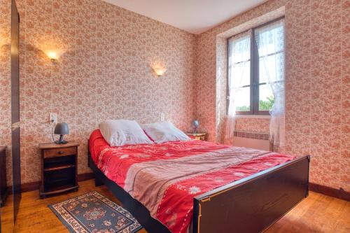 - une chambre avec un lit doté de draps rouges et une fenêtre dans l'établissement La Coccinelle - Perigord Noir, à Saint-Geniès
