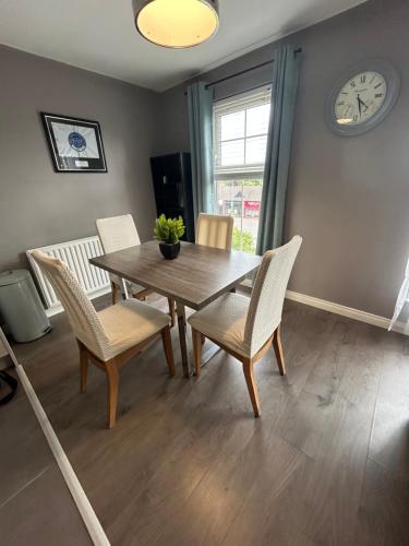 a dining room with a table and chairs and a clock at Saffron Loft, Belfast in Belfast