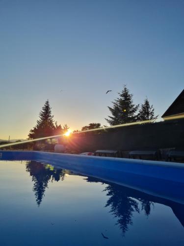 a pool of water with the sunset in the background at Kamena kuća Goranci in Mostar
