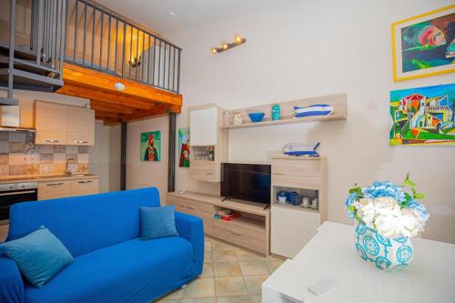 un salon avec un canapé bleu et une table dans l'établissement Argentario IL SOLE, à Porto Santo Stefano