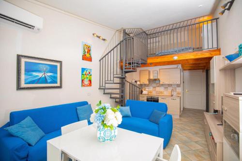 un salon avec des canapés bleus et une table dans l'établissement Argentario IL SOLE, à Porto Santo Stefano