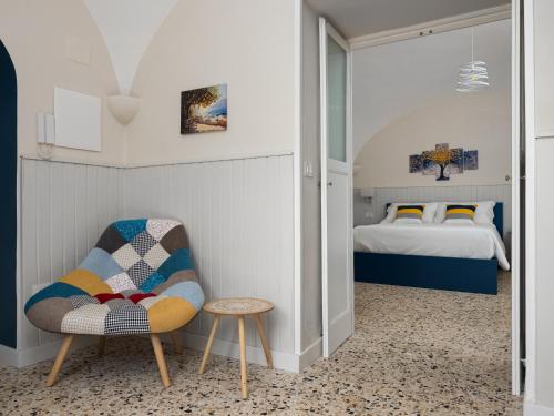 a bedroom with a bed and a chair and a table at EMMEhouse in Sant'Agnello