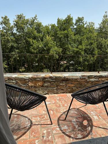 two black chairs sitting on a brick patio at Chambres d'hote Bergerie A Maredda in Murato