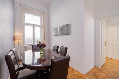 a dining room table with chairs and a vase of flowers at City Hotel Matyas in Budapest