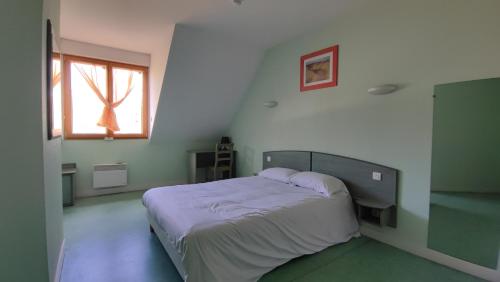 a bedroom with a bed in a room with a window at Ternelia Village vacances Sainte Montaine in Sainte-Montaine