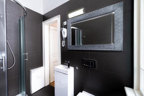 a bathroom with a toilet and a mirror at City Hotel Matyas in Budapest