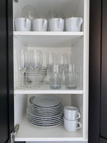 a cupboard filled with glasses and plates and cups at Marbella Beach View and Pool in Marbella