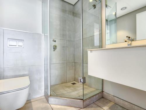 a bathroom with a shower and a toilet at Skyline views Stylish Studio with Pool, parking no load shedding in Cape Town