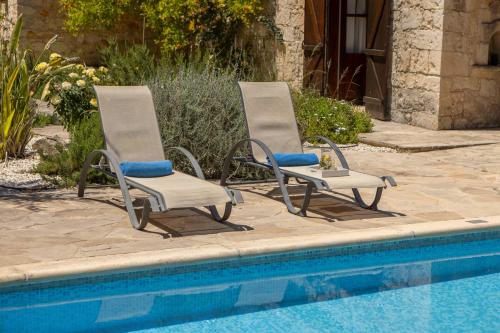 two lounge chairs sitting next to a swimming pool at Simeon Estate in Droushia