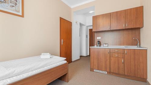 a bedroom with a bed and a sink and cabinets at Hotel Samechov - konferenční hotel in Samechov