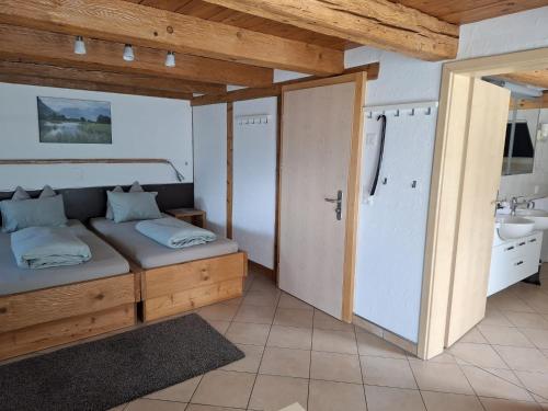 a bedroom with a bed and a bathroom with a sink at Hotel & Restaurant Rössli in Seedorf