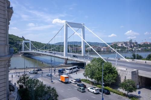 a white bridge over a river with cars parked at City Hotel Matyas in Budapest