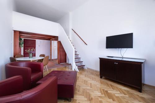 a living room with a couch and a tv and a table at City Hotel Matyas in Budapest