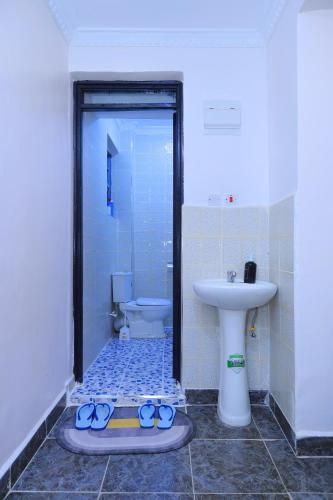 a bathroom with a shower with a sink and a pair of scissors at 1 bedroom in Kamakis in Ruiru