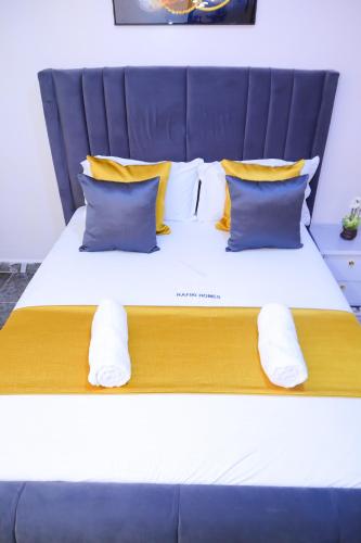 a large bed with yellow and blue pillows at 1 bedroom in Kamakis in Ruiru