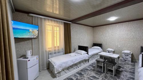a hospital room with two beds and a flat screen tv at УЮТ отель и хостел in Jalal-Abad