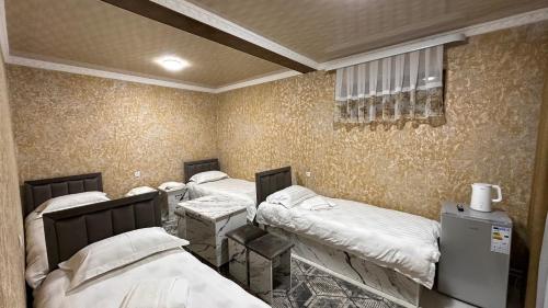 a group of four beds in a room at УЮТ отель и хостел in Jalal-Abad