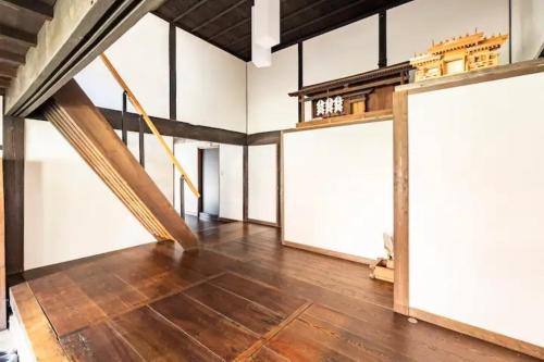 an empty room with a wooden floor and stairs at Former inn "Oyado Wada-juku" - Vacation STAY 03818v in Nagawa