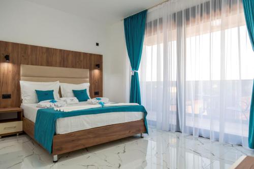 a bedroom with a large bed and a large window at Hotel Lejla in Ulcinj
