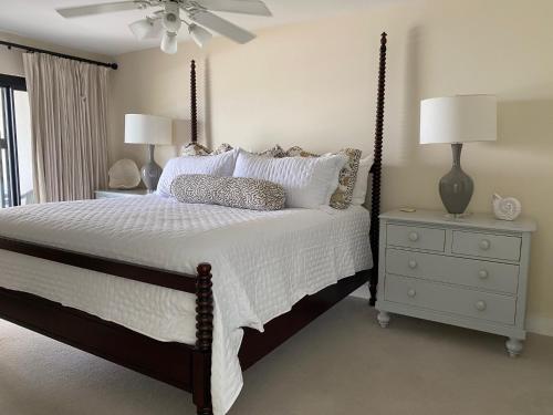 a bedroom with a bed and a dresser with a lamp at 417 Seascape Villas, Beachfront! Stunning Views! Pool! in Isle of Palms
